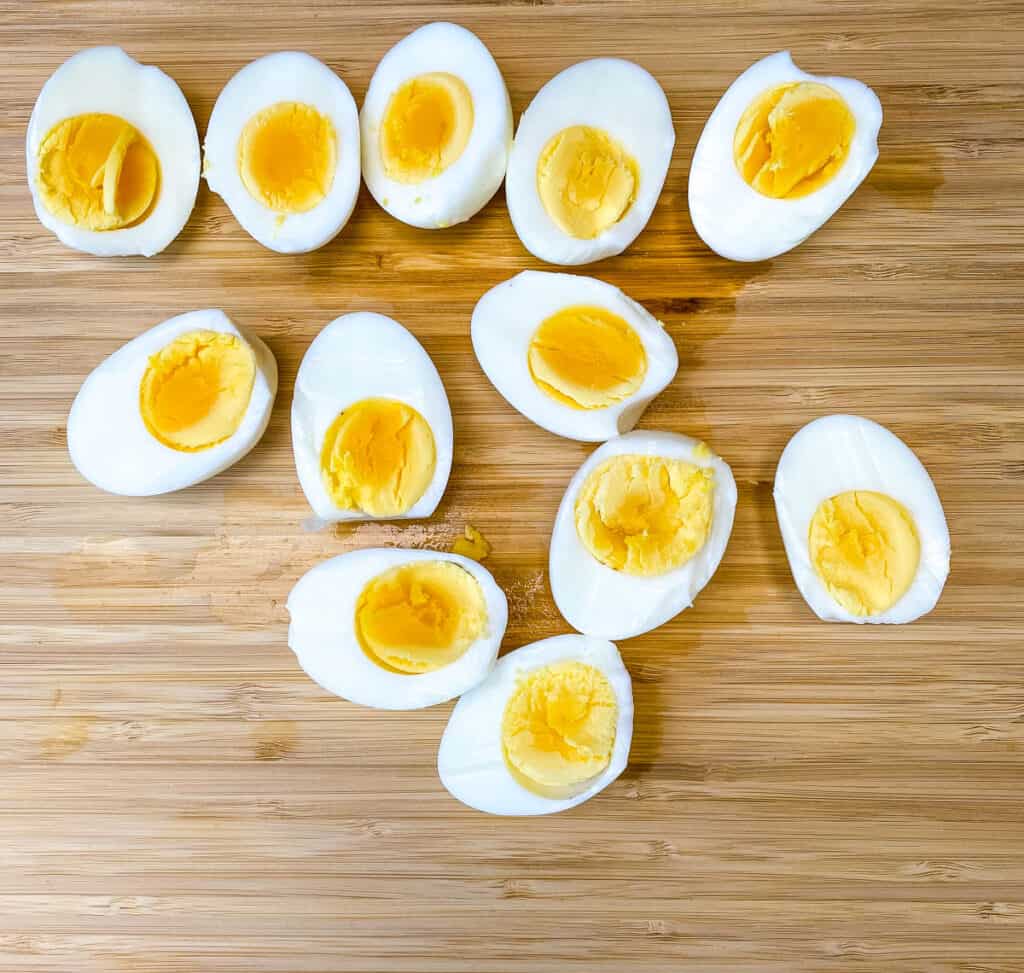 hard boiled eggs cut in half on a bamboo cutting board