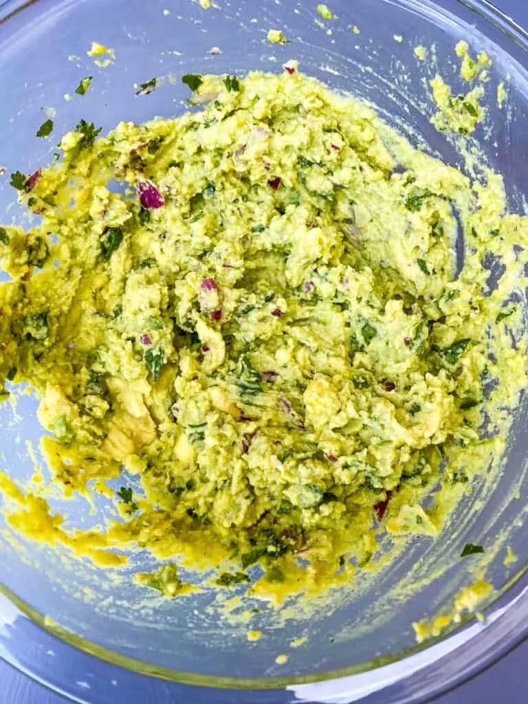 mashed guacamole in a glass bowl
