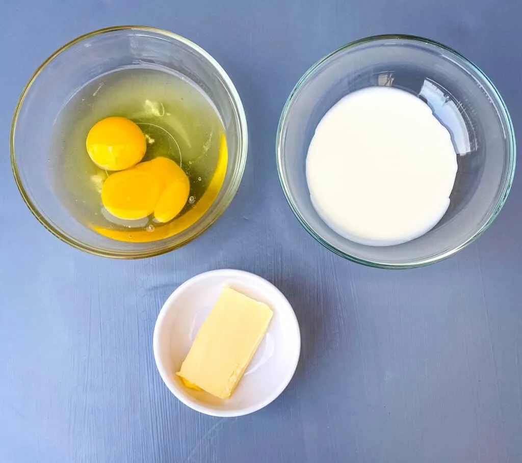 raw eggs, heavy cream, and butter in separate bowls