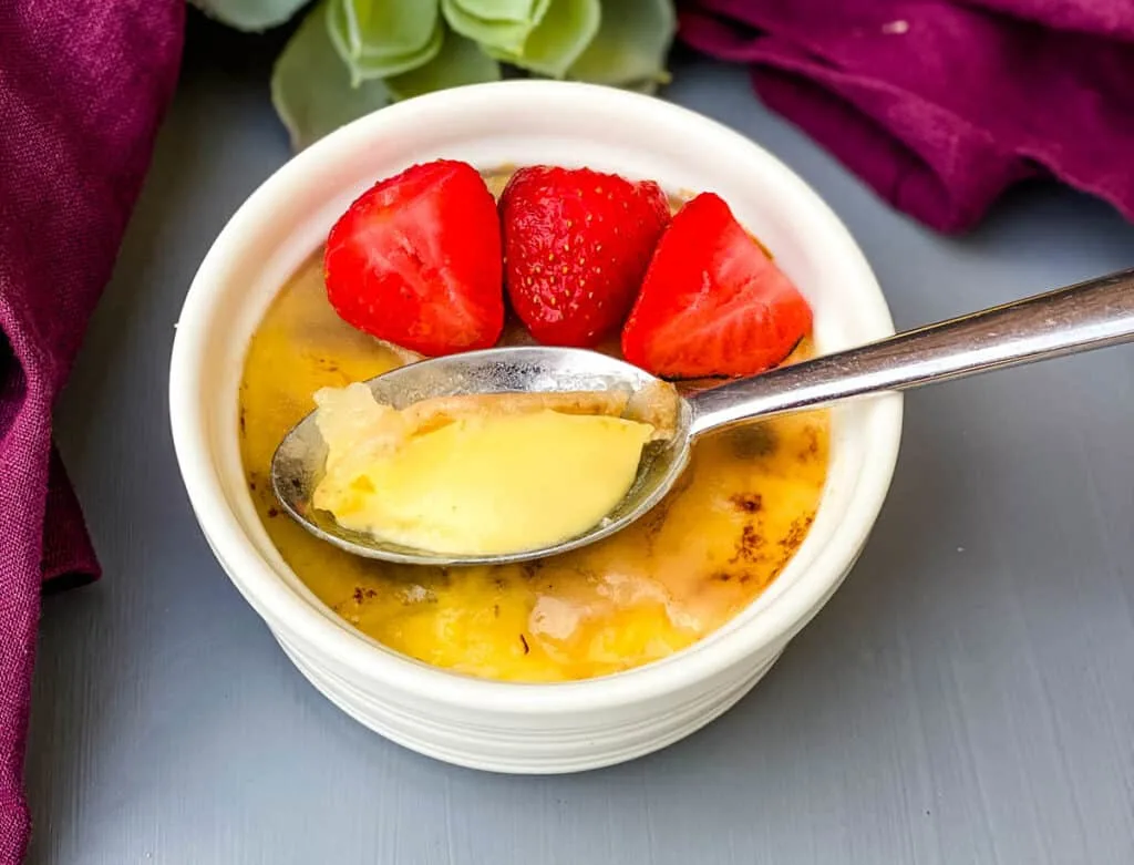 keto low carb Crème brûlée in a white ramekin with strawberries on top