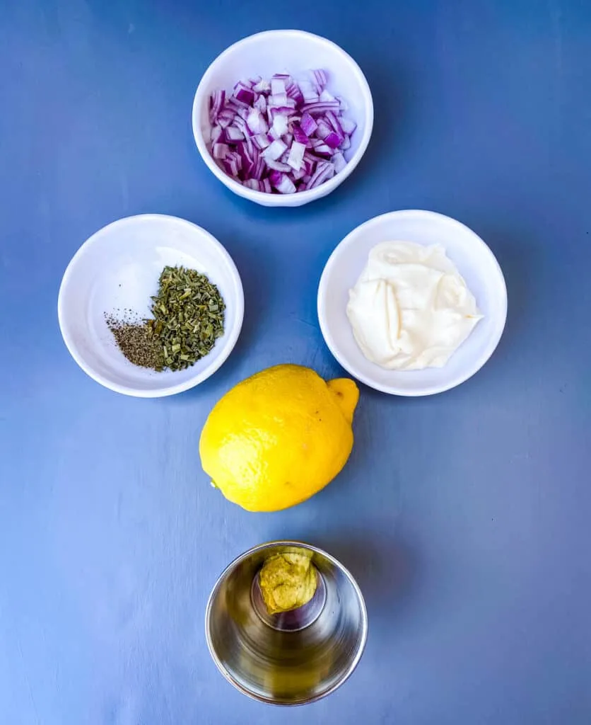 chopped onions, mayo, chives, and mustard in separate bowls with a fresh lemon