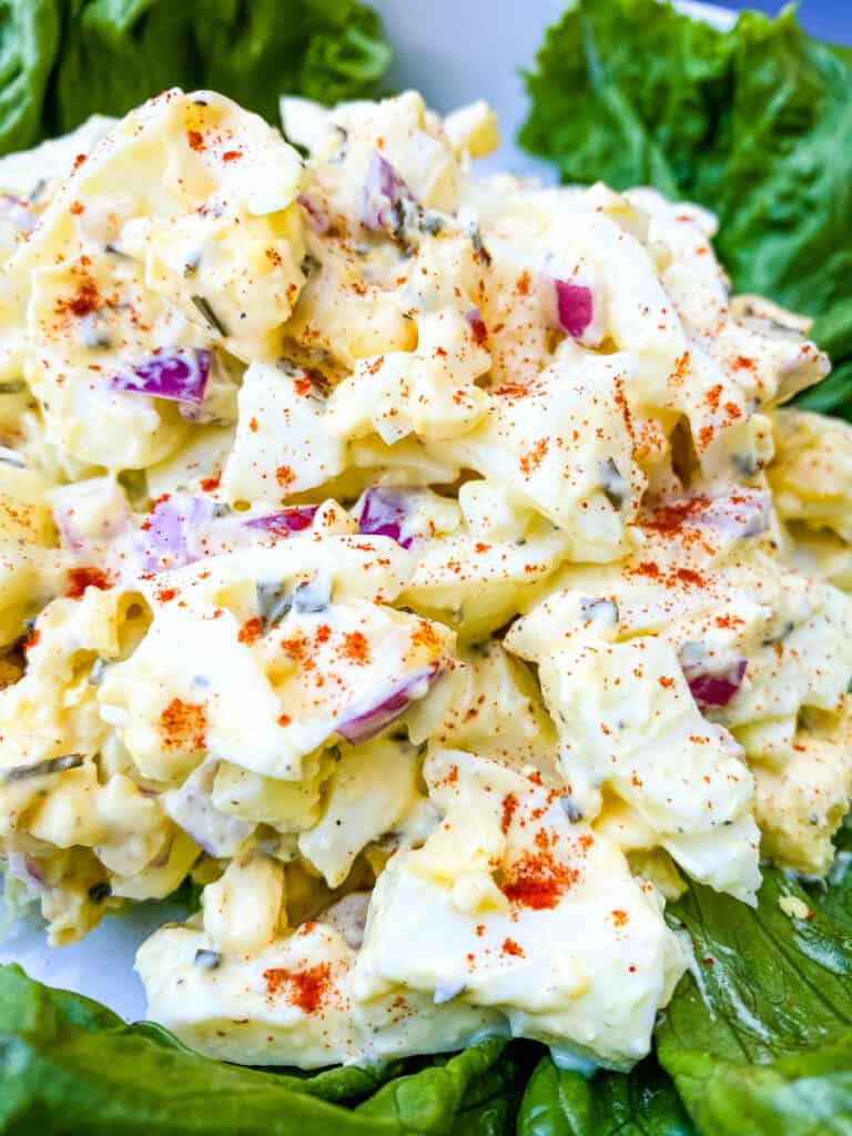 keto low carb egg salad on a bed of lettuce in a white bowl