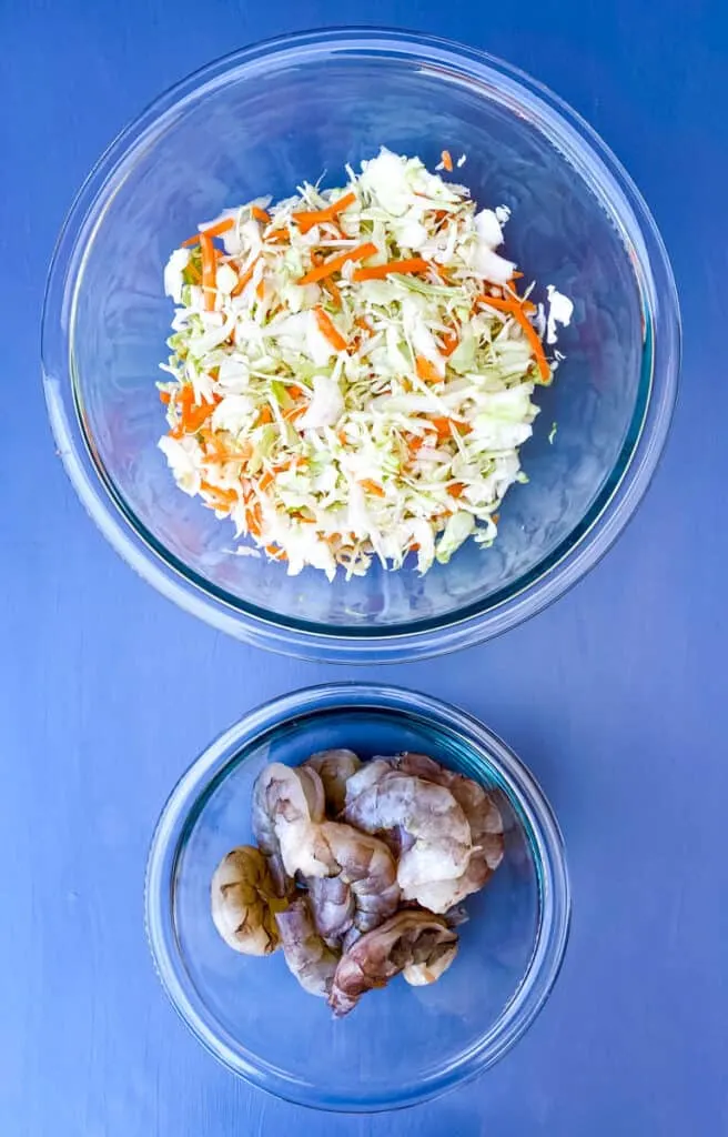 coleslaw mix and raw shrimp in seperate bowls