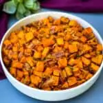 air fryer sweet potato hash with chopped bacon in a white bowl