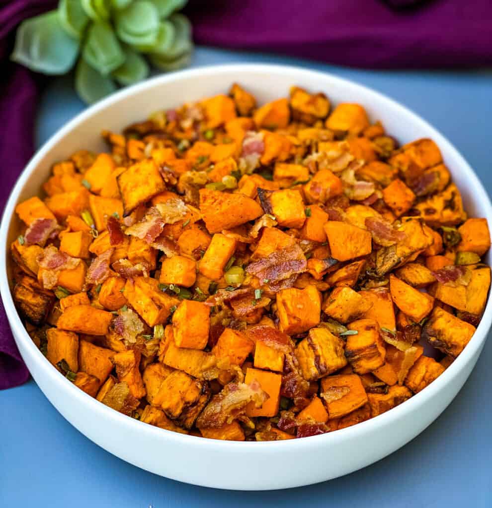 air fryer sweet potato hash with chopped bacon in a white bowl