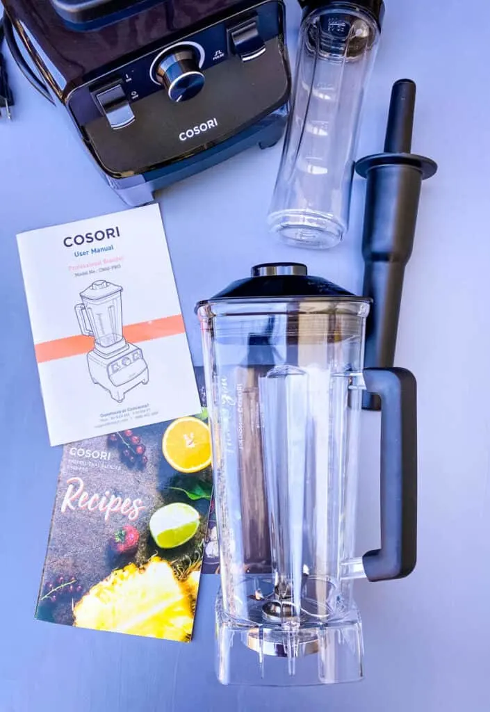 Cosori professional blender and travel cup on a flat surface