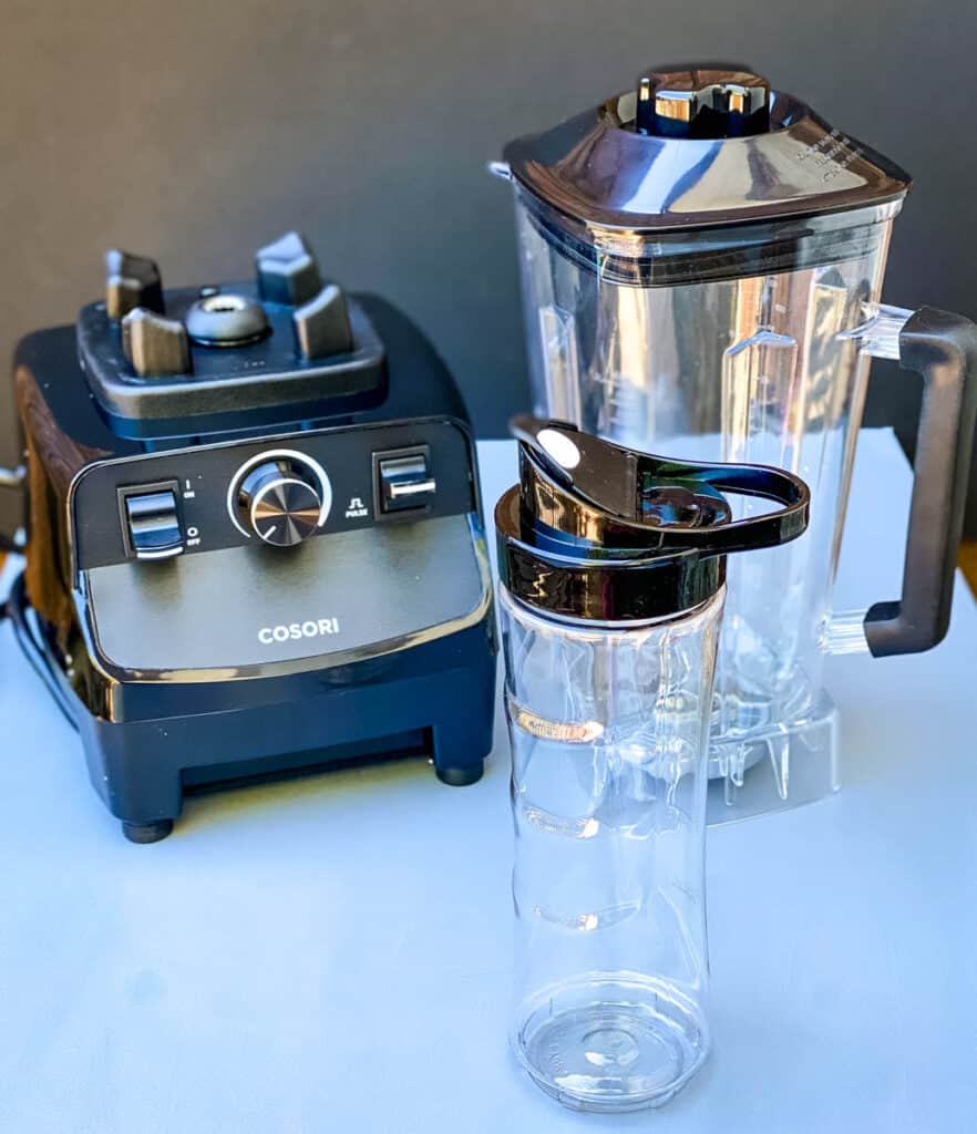 Cosori professional blender and travel cup on a flat surface