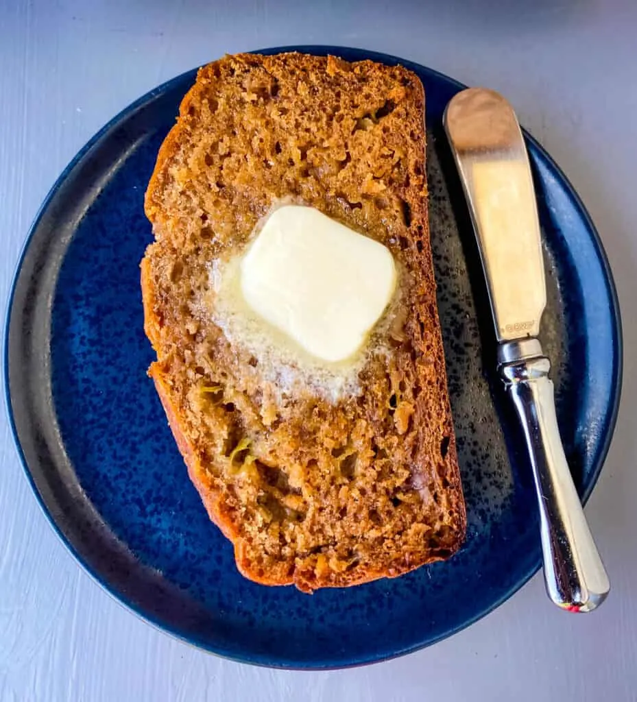 a slice of healthy banana bread on a blue plate with butter