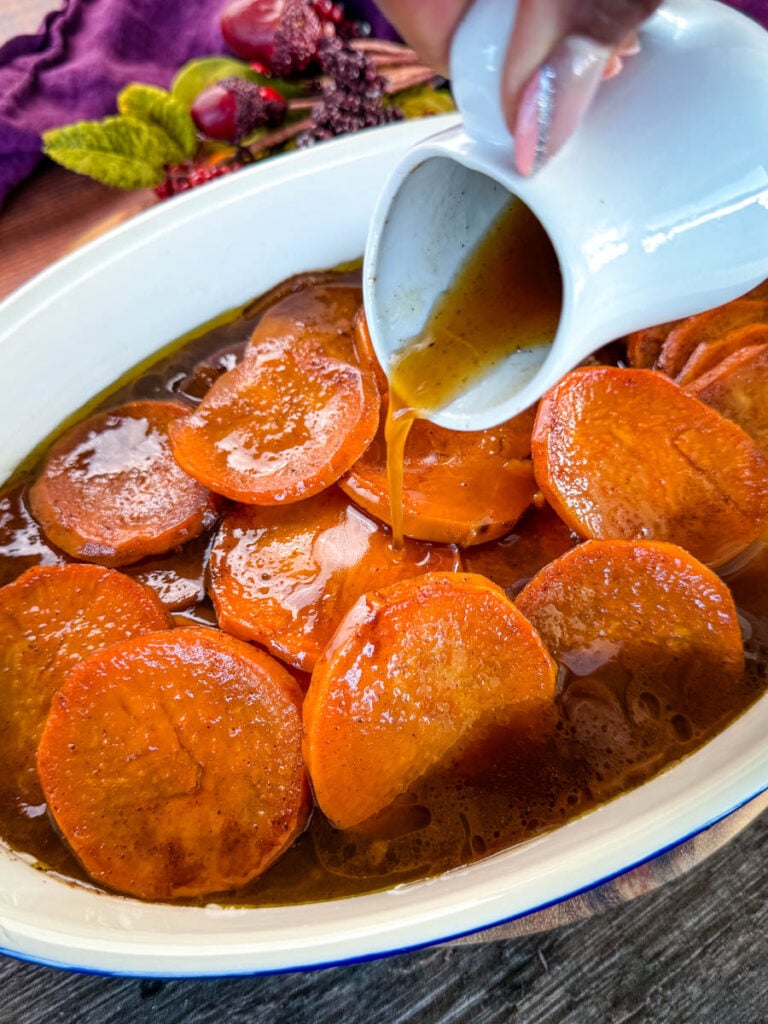 a spoonful of southern candied sweet potato yams in a baking dish