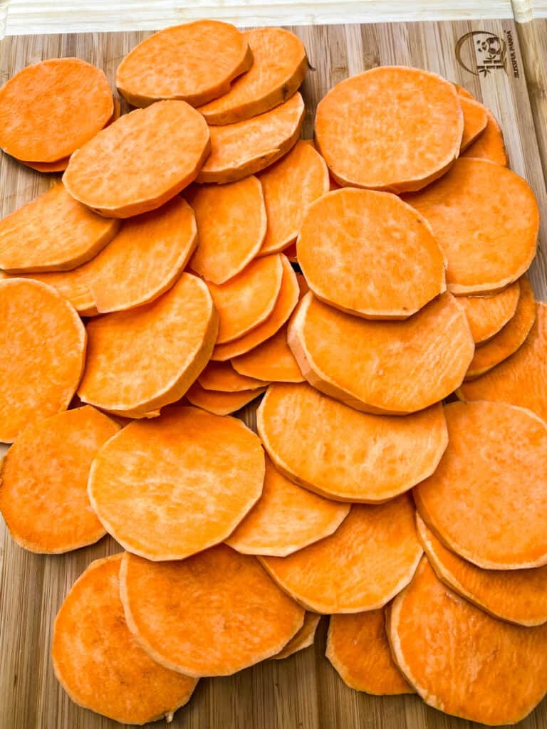 raw sliced sweet potatoes on a cutting board