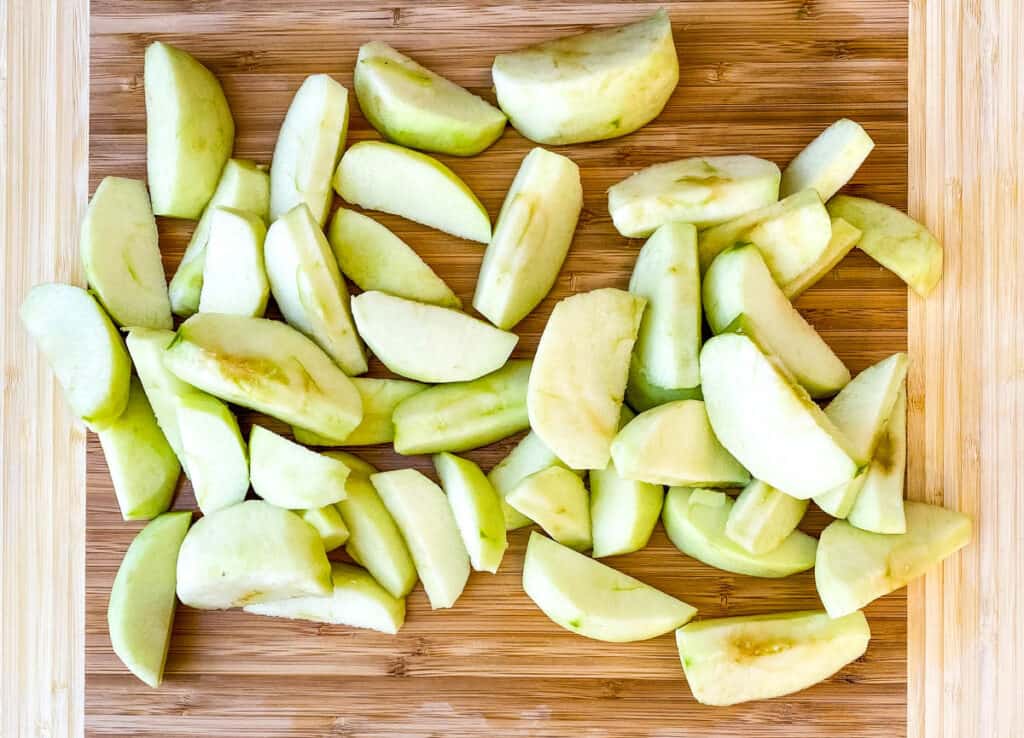 sliced Granny Smith apples on a bamboo cutting board