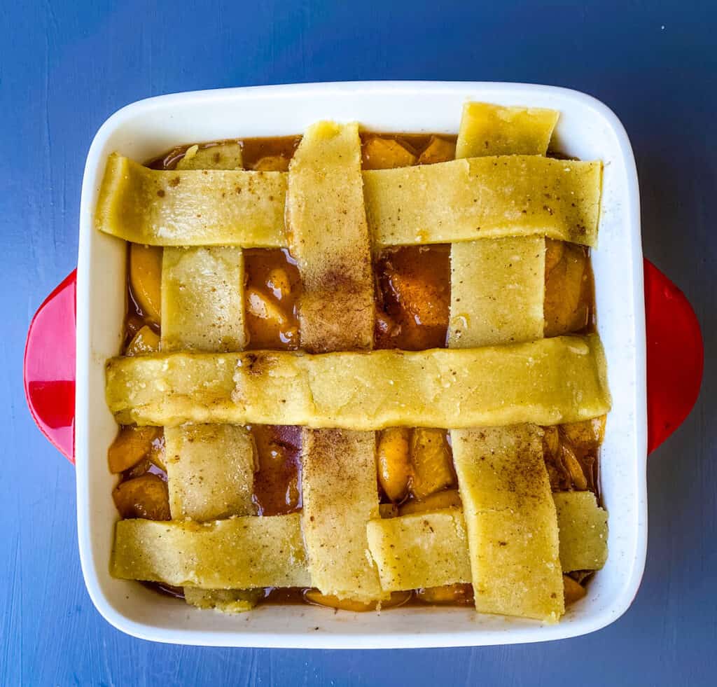 unbaked healthy Southern peach cobbler in a red baking dish