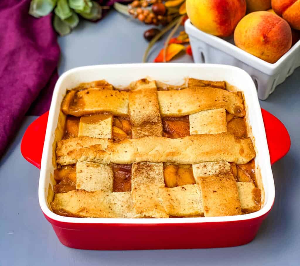 healthy southern peach cobbler in a red baking dish
