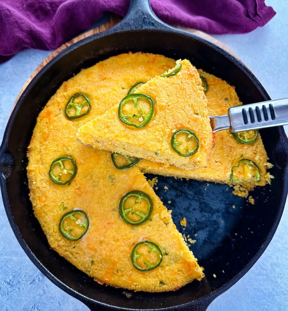 jalapeno cheddar cornbread with butter in a cast iron skillet