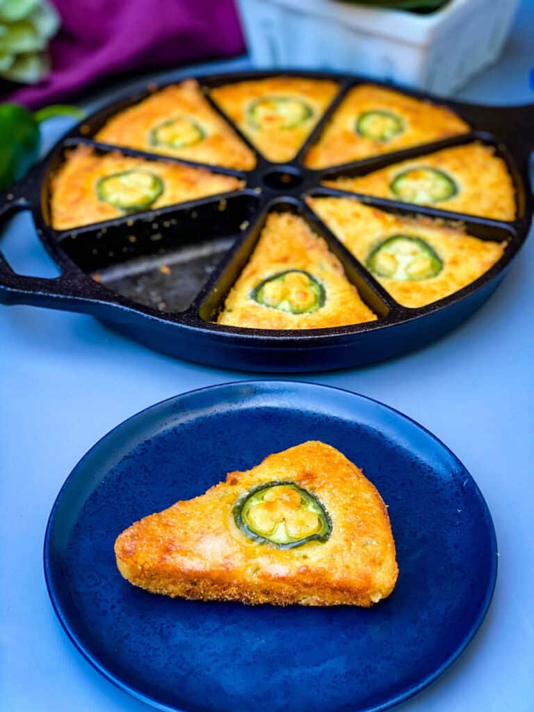 a plate of jalapeno cheddar cornbread along with jalapeno cheddar cornbread in a cast iron wedge pan