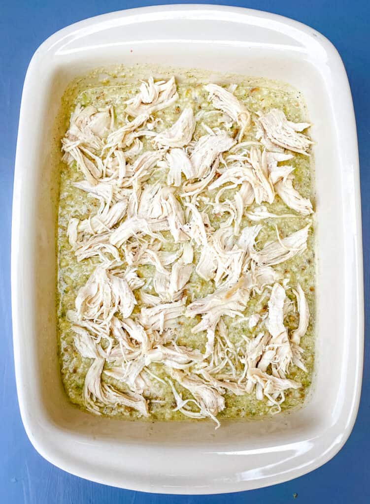 unbaked cornbread dressing with chicken in a baking dish