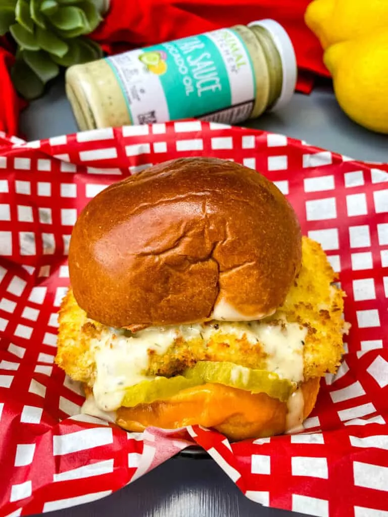 air fryer fish sandwich on a bun with melted cheese and tartar sauce