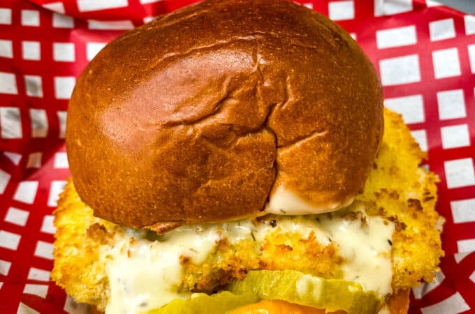air fryer fish sandwich on a bun with melted cheese and tartar sauce