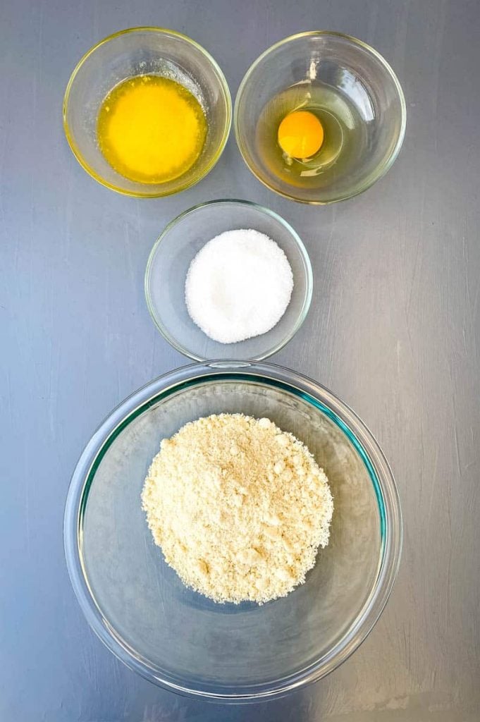 melted butter, raw egg, sweetener, and almond flour in separate glass bowls