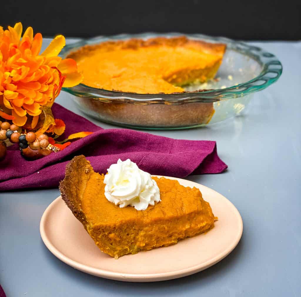 healthy sweet potato pie on a pie plate with whipped cream