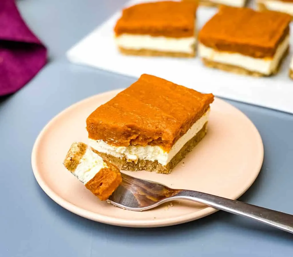 pumpkin cheesecake bars on a pink plate