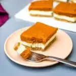 pumpkin cheesecake bars on a pink plate