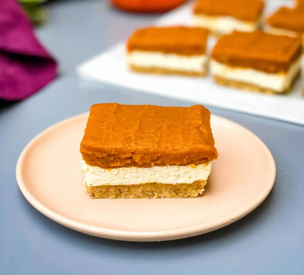 pumpkin cheesecake bars on a pink plate