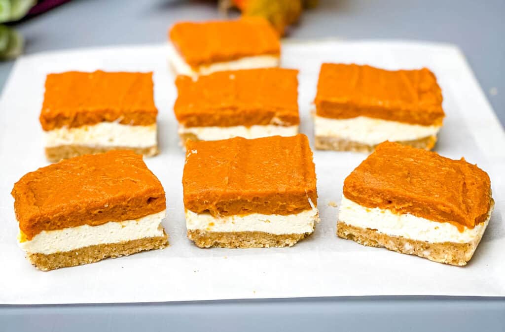 pumpkin cheesecake bars on parchment paper