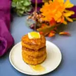 sweet potato biscuits on a plate with butter drizzled in honey