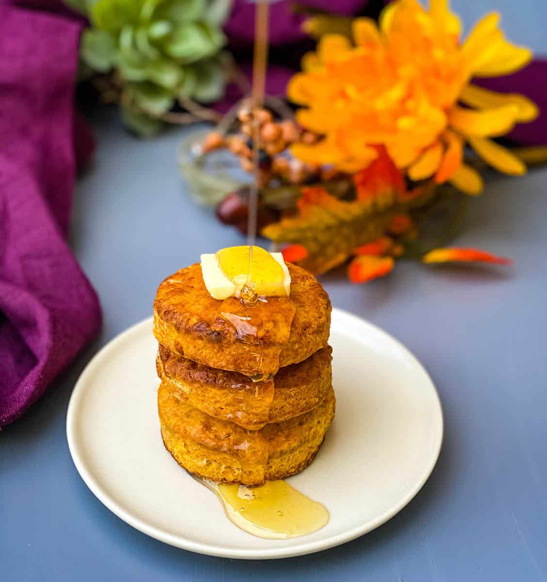 sweet potato biscuits on a plate with butter drizzled in honey