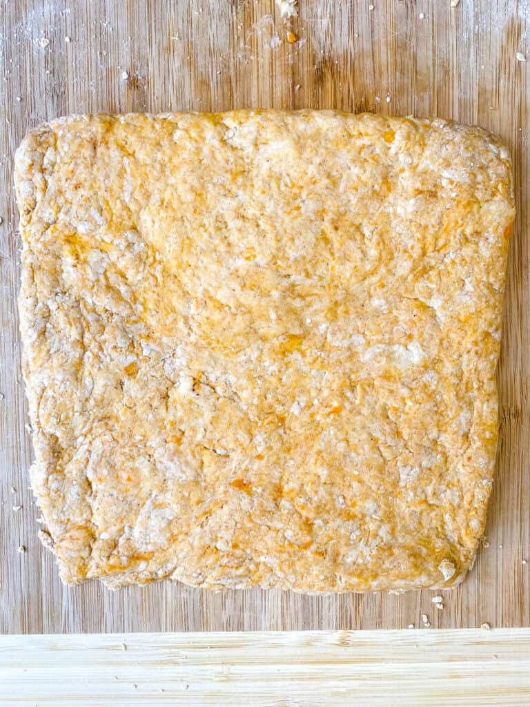 sweet potato biscuit dough on a bamboo cutting board