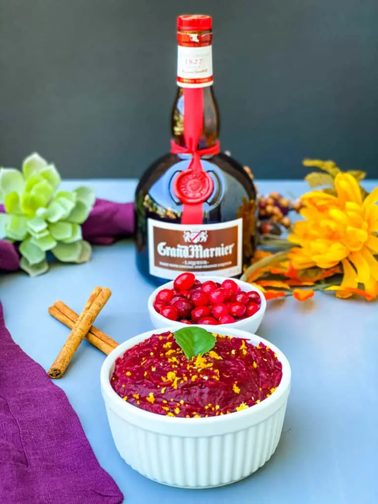 Grand Marnier cranberry sauce in a white bowl with a bottle of Grand Marnier