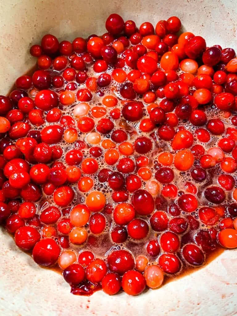 cranberries in a pot with cinnamon, honey, and sweetener