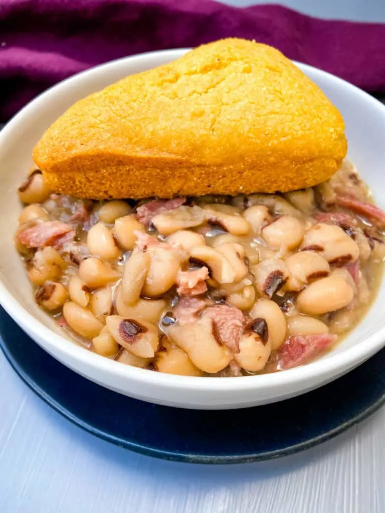 Instant Pot black eyed peas in a white bowl with cornbread