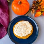 keto pumpkin cookies with cream cheese frosting and cinnamon on a blue plate