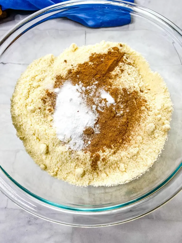 almond flour, pumpkin pie spice, baking powder, and baking soda in a glass bowl