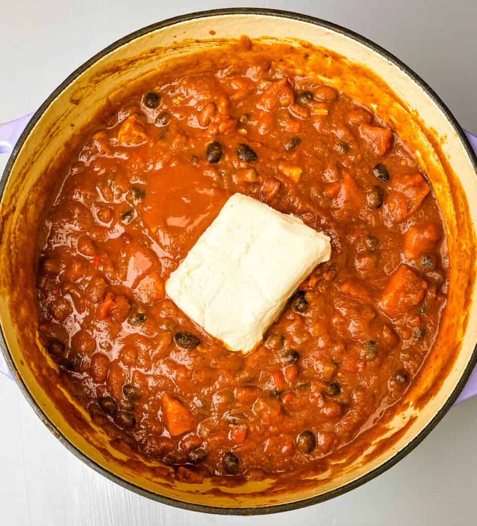 pumpkin chicken chili with cream cheese in a Dutch oven