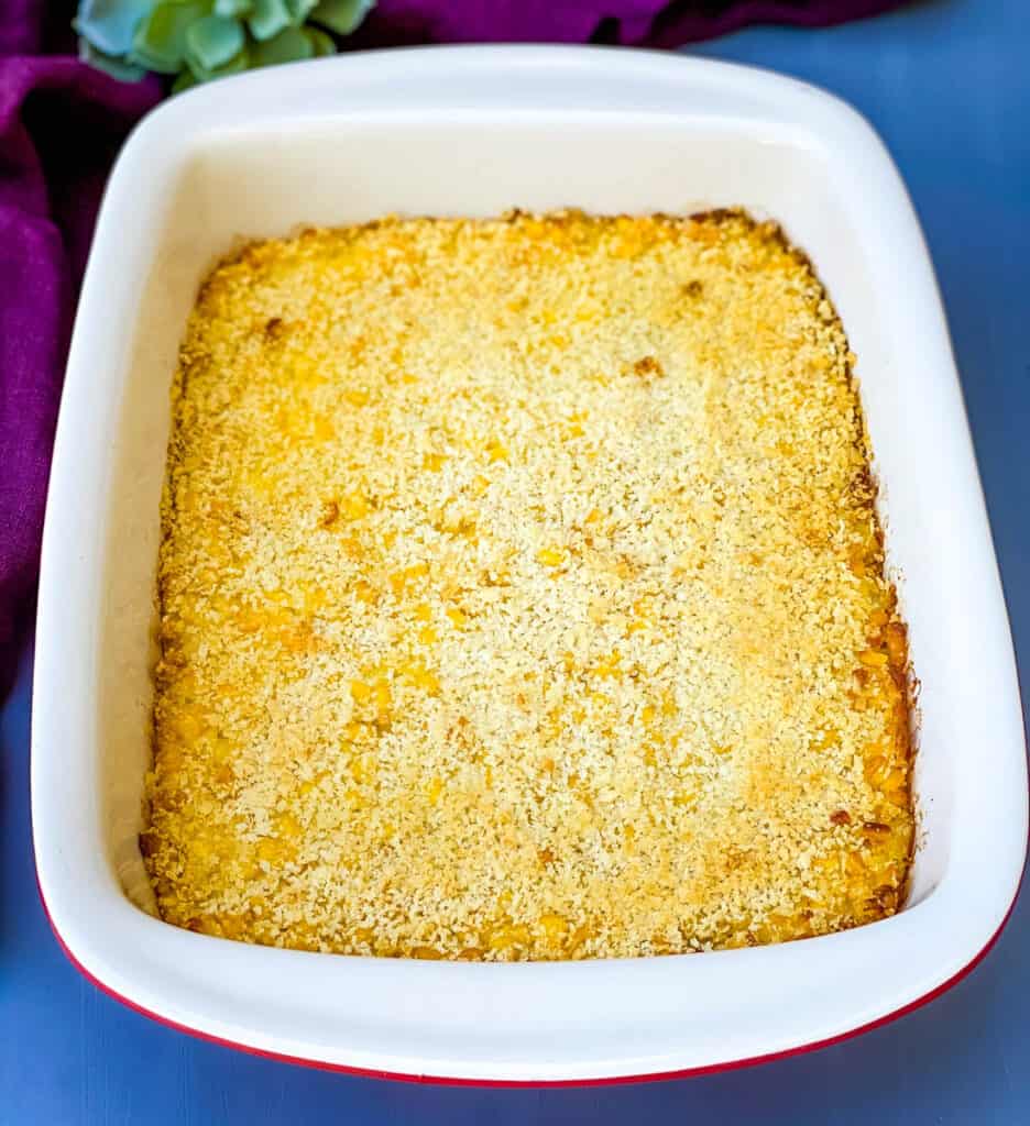 scalloped corn in a red baking dish