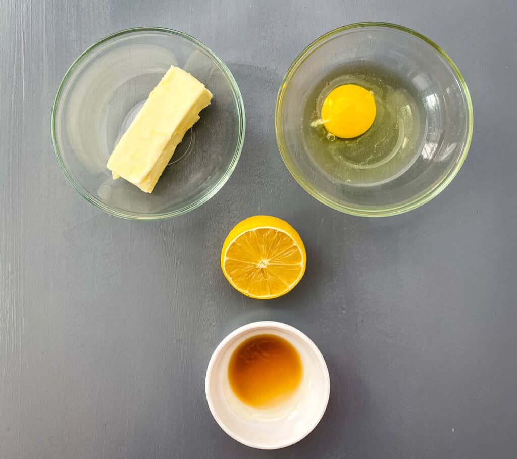 butter, egg, lemon, and vanilla extract on a flat surface