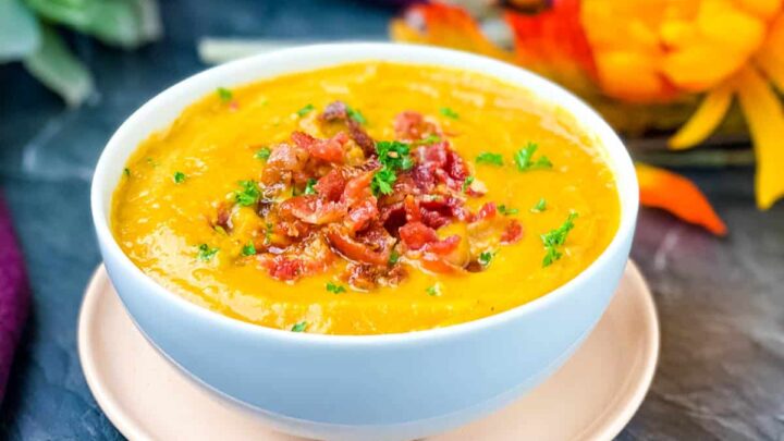 sweet potato soup in a white bowl with chunks of bacon