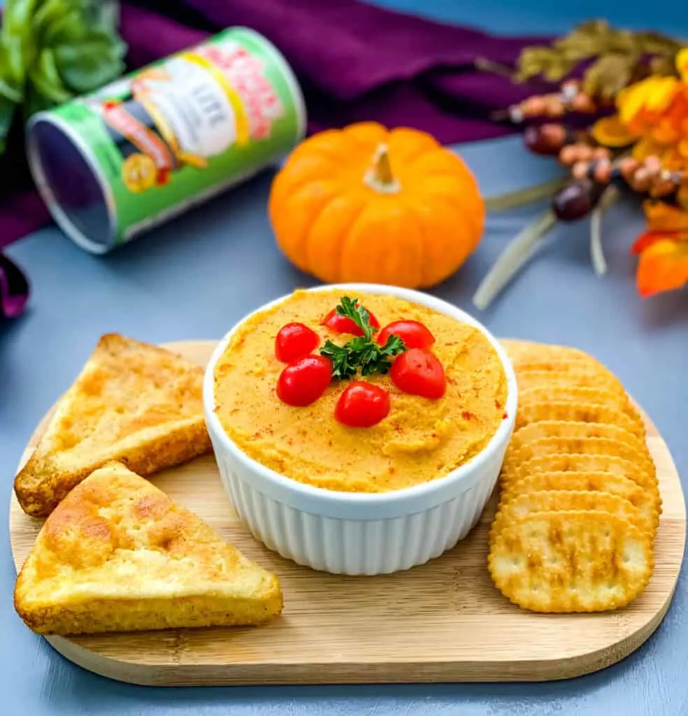 pumpkin hummus on a cutting board with cornbread and crackers