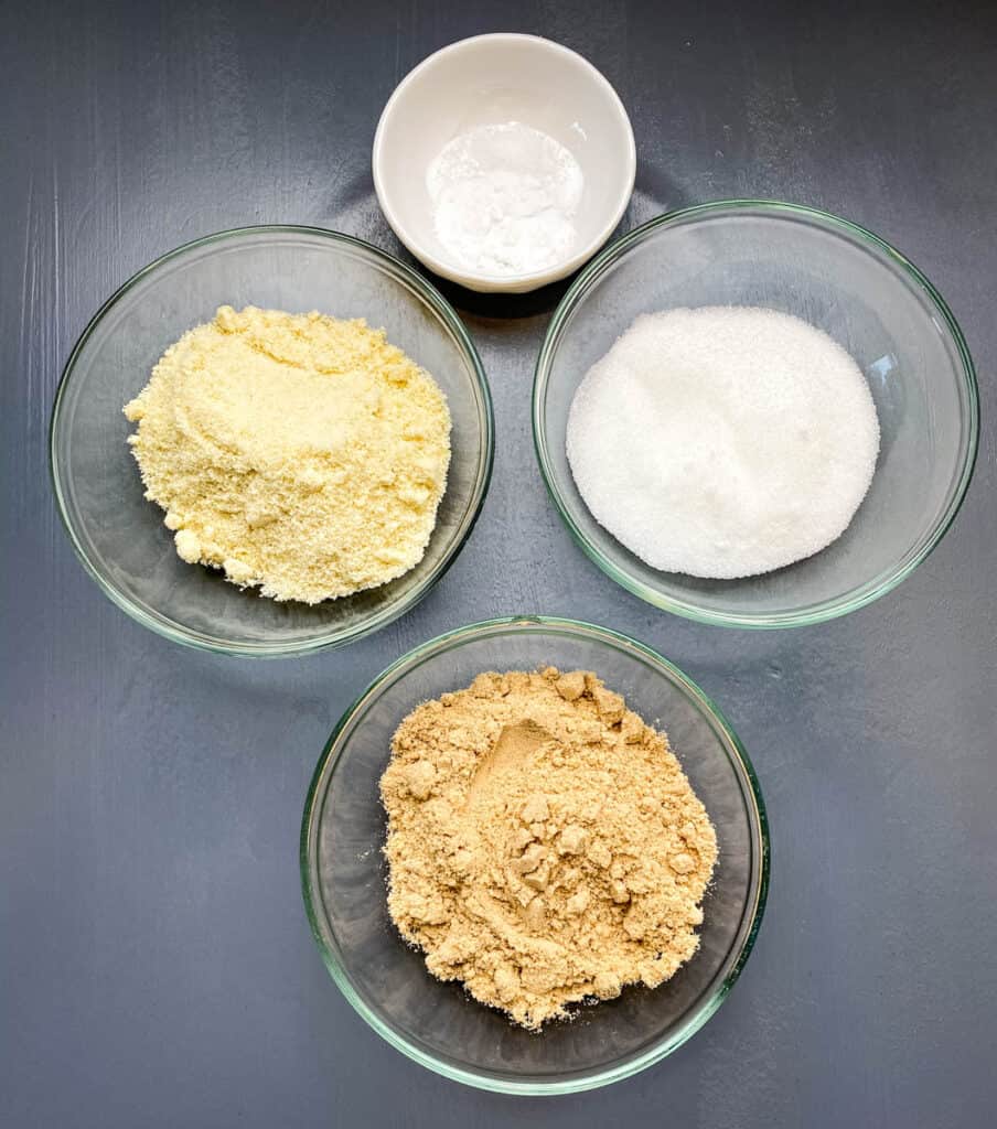 almond flour, sweetener, baking soda, and collagen in separate glass bowls on a flat surface