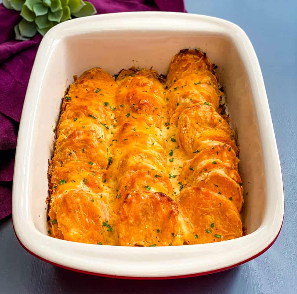 au gratin sweet potatoes in a red baking dish