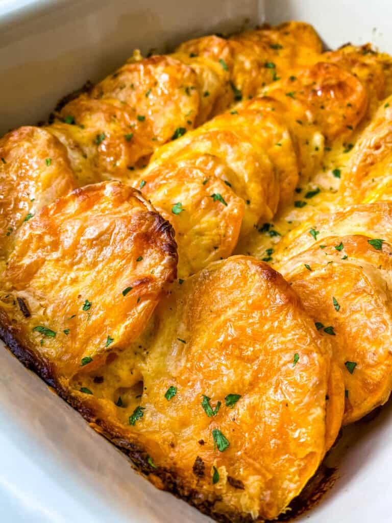 au gratin sweet potatoes in a red baking dish