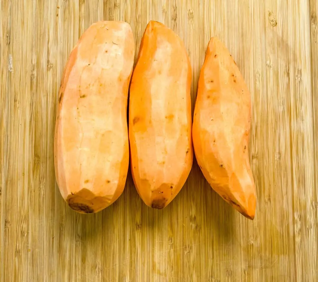 raw sweet potatoes on a cutting board