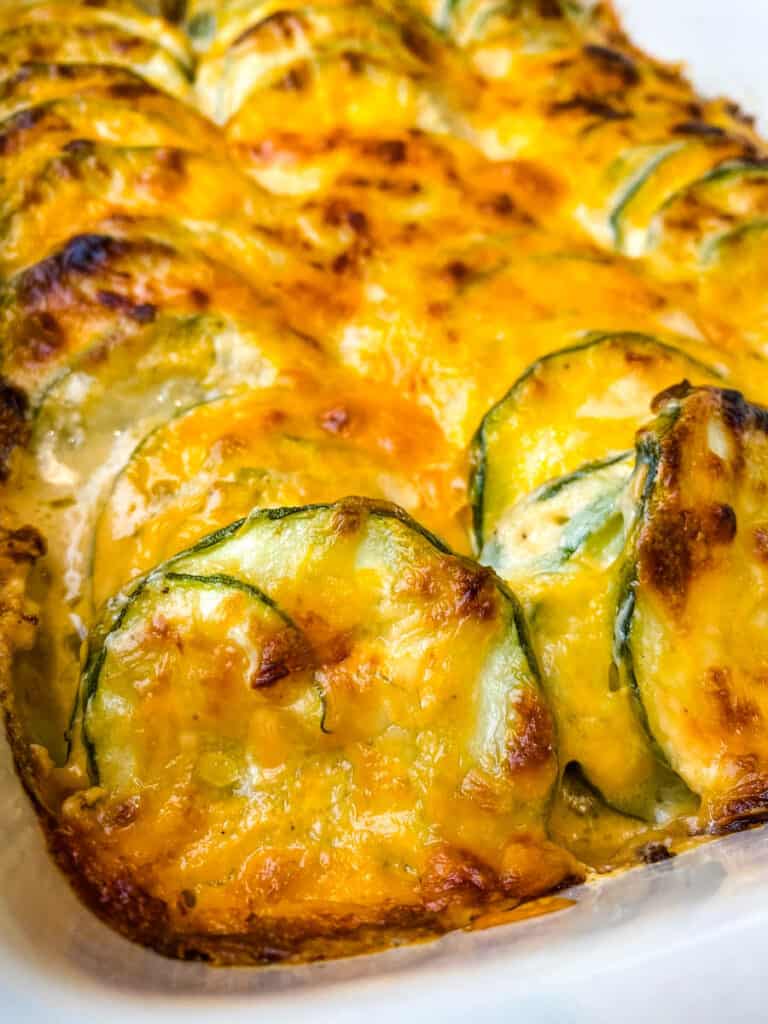 zucchini au gratin scalloped potatoes in a red baking dish