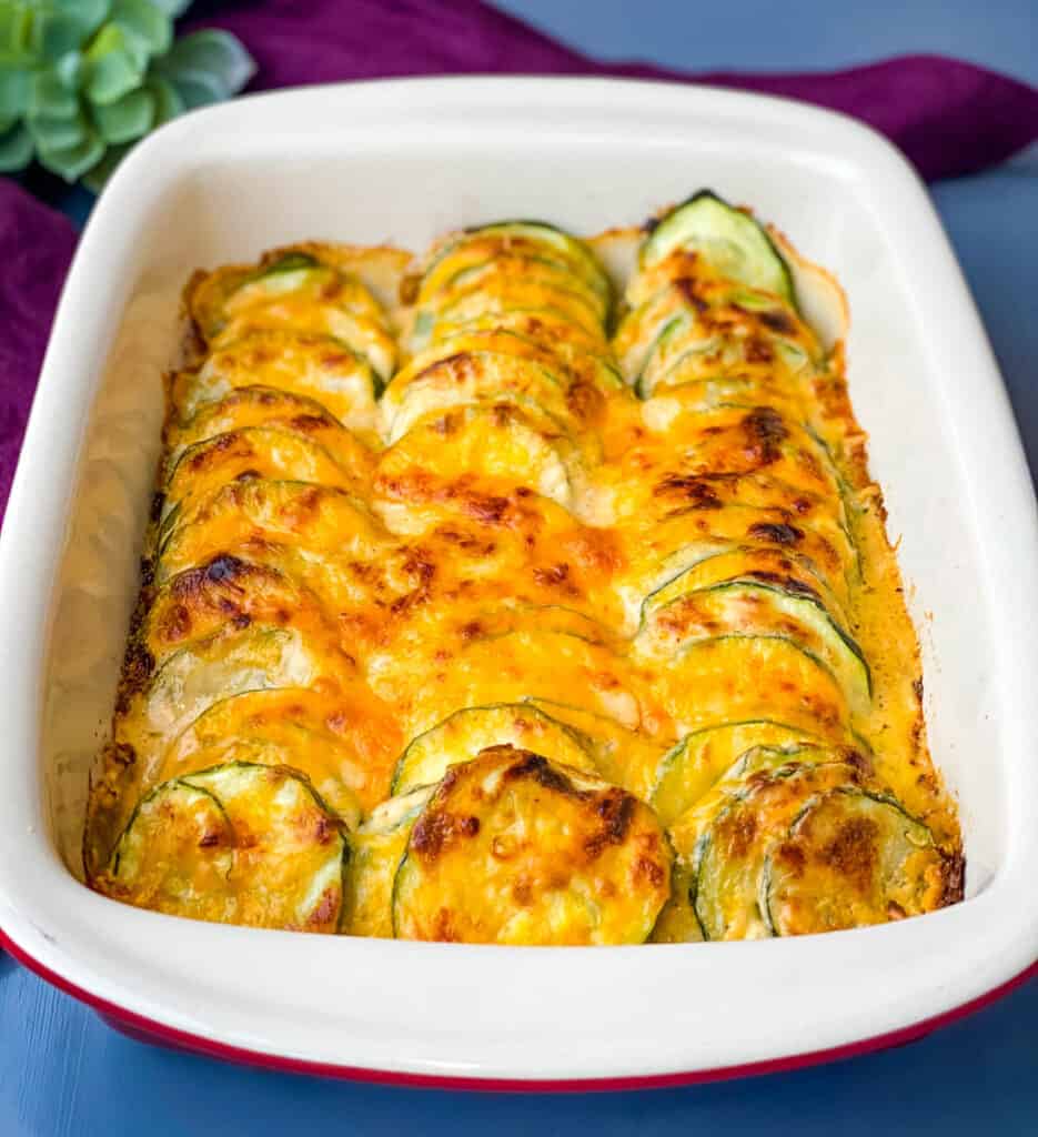 zucchini au gratin scalloped potatoes in a red baking dish