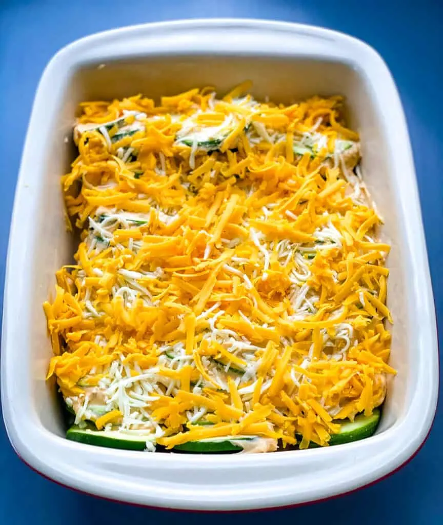 unbaked zucchini au gratin scalloped potatoes in a red baking dish