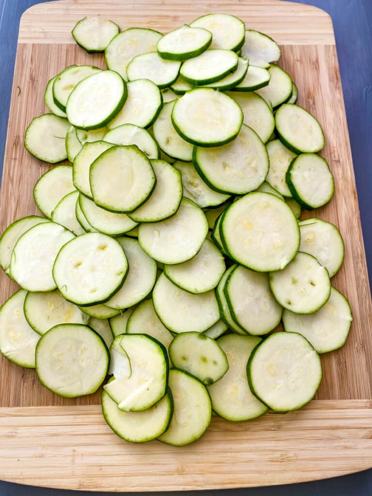 sliced round zucchini on a bamboo cutting board