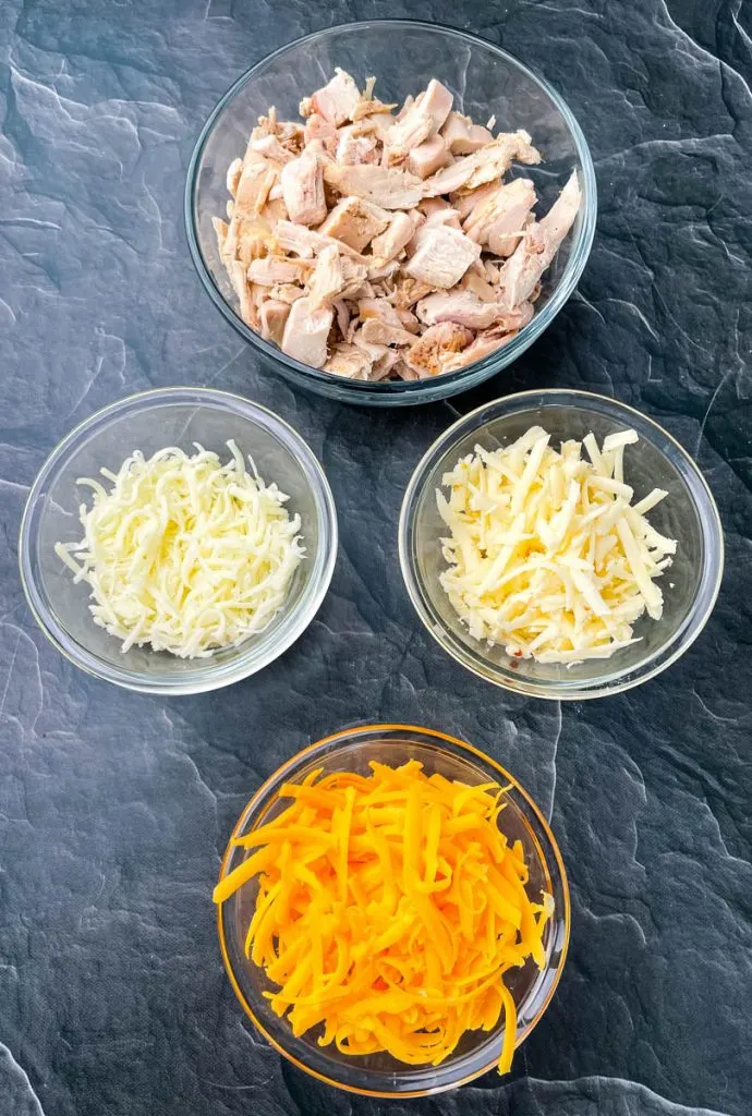 cooked turkey, shredded cheese in glass bowls